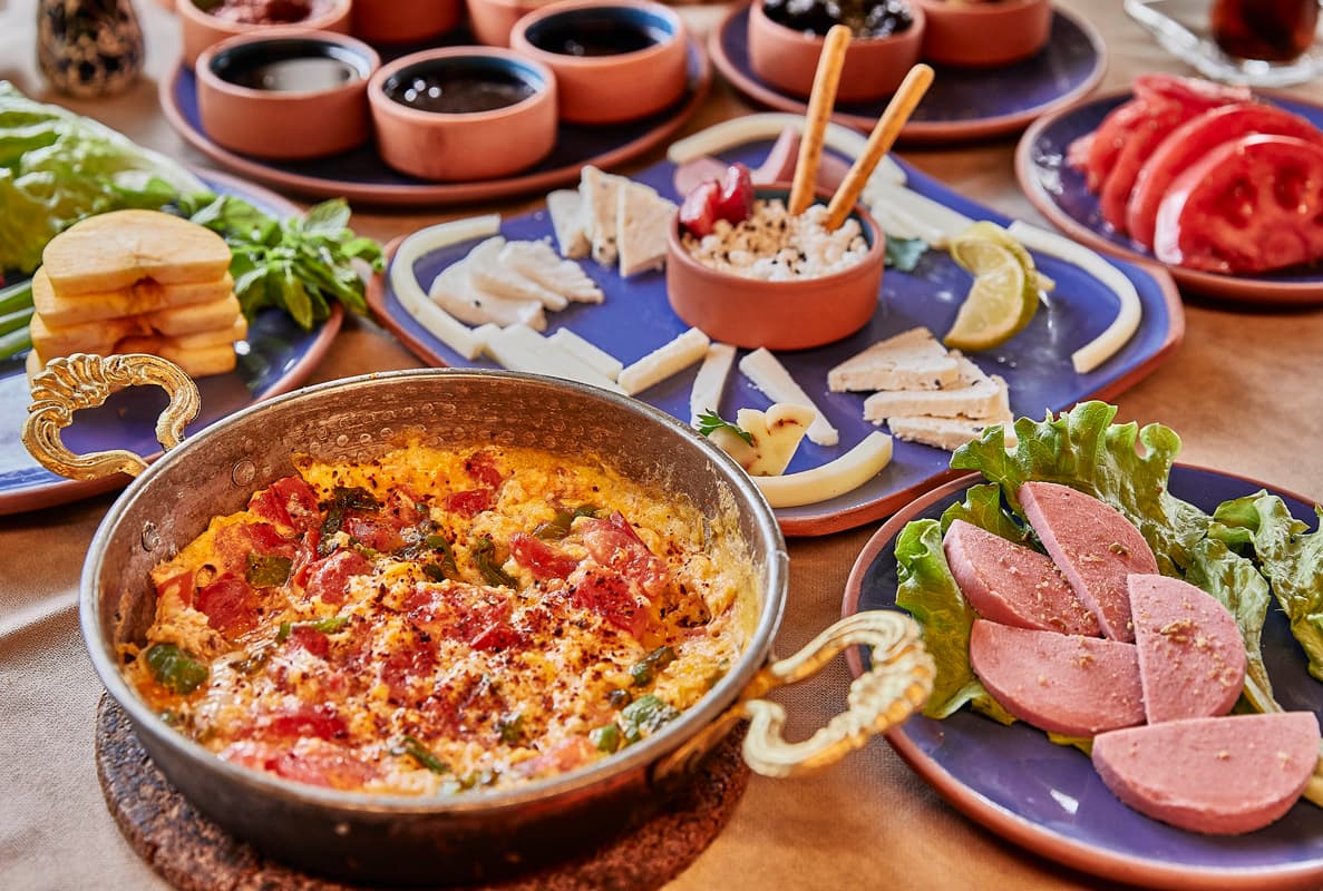 Bakır tabakta menemen ve serpme kahvaltı sofrası